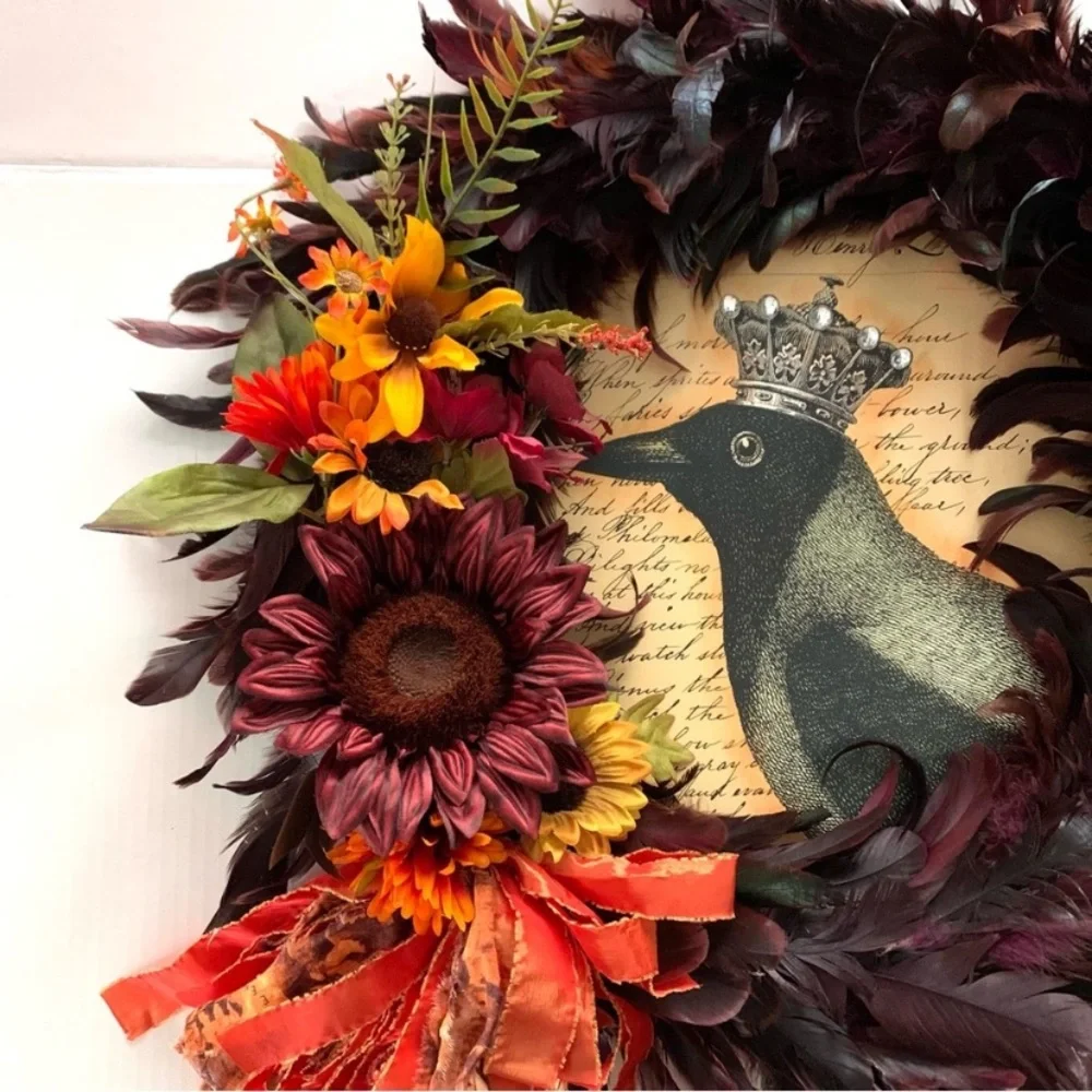 Dark red and black feather wreath with fall floral and a crowned crow center